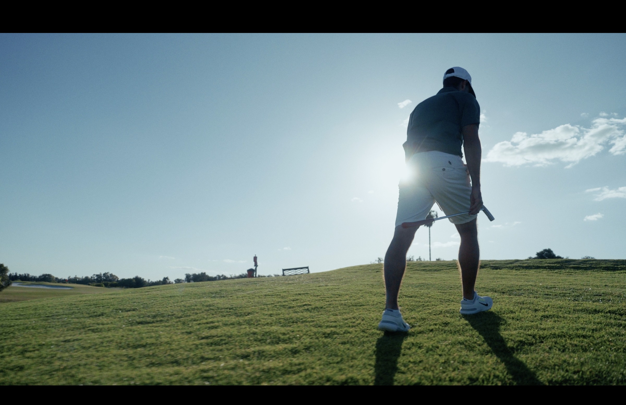 Golfer silhouetted against a bright sky in a DHM film
